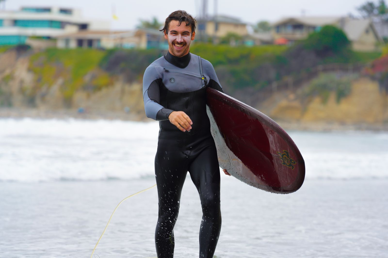 People photo — surfer walking up the beach with his board